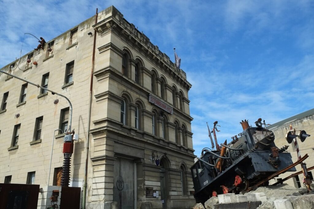 Steampunk-costumed visitors outside a limestone building in the Victorian Precinct of Ōamaru, New Zealand.