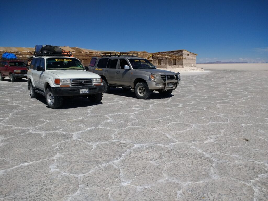 Vehicles in front of a salt hotel in the Salar de Uyuni.